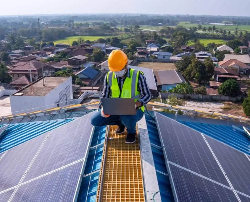 Asian technician checks the maintenance of the solar panels on the roof