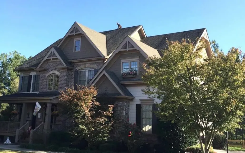 NewImageRoof_Front view of house with guy on rooft
