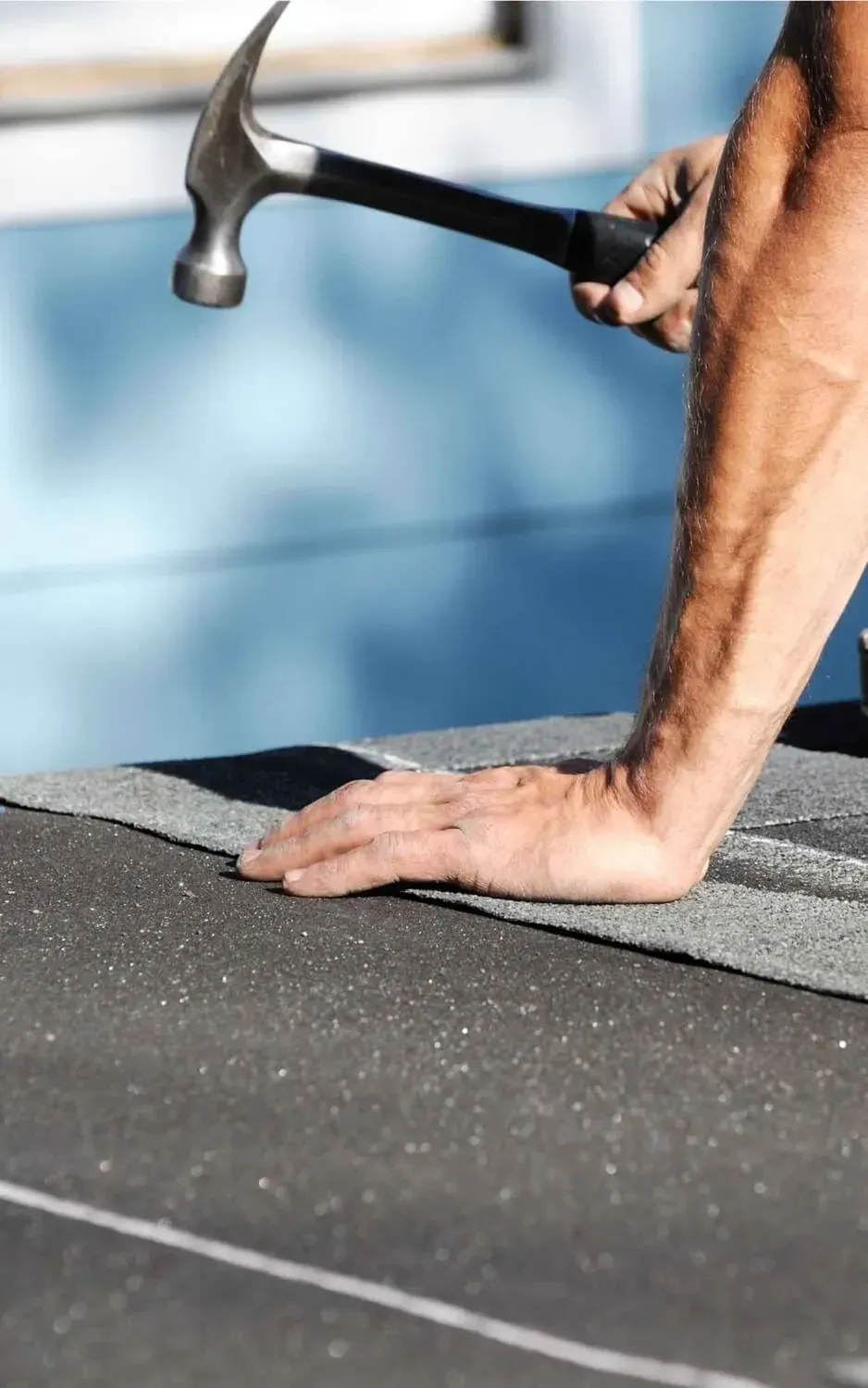 New_Image_Roof_worker using hammer on shingles vertical