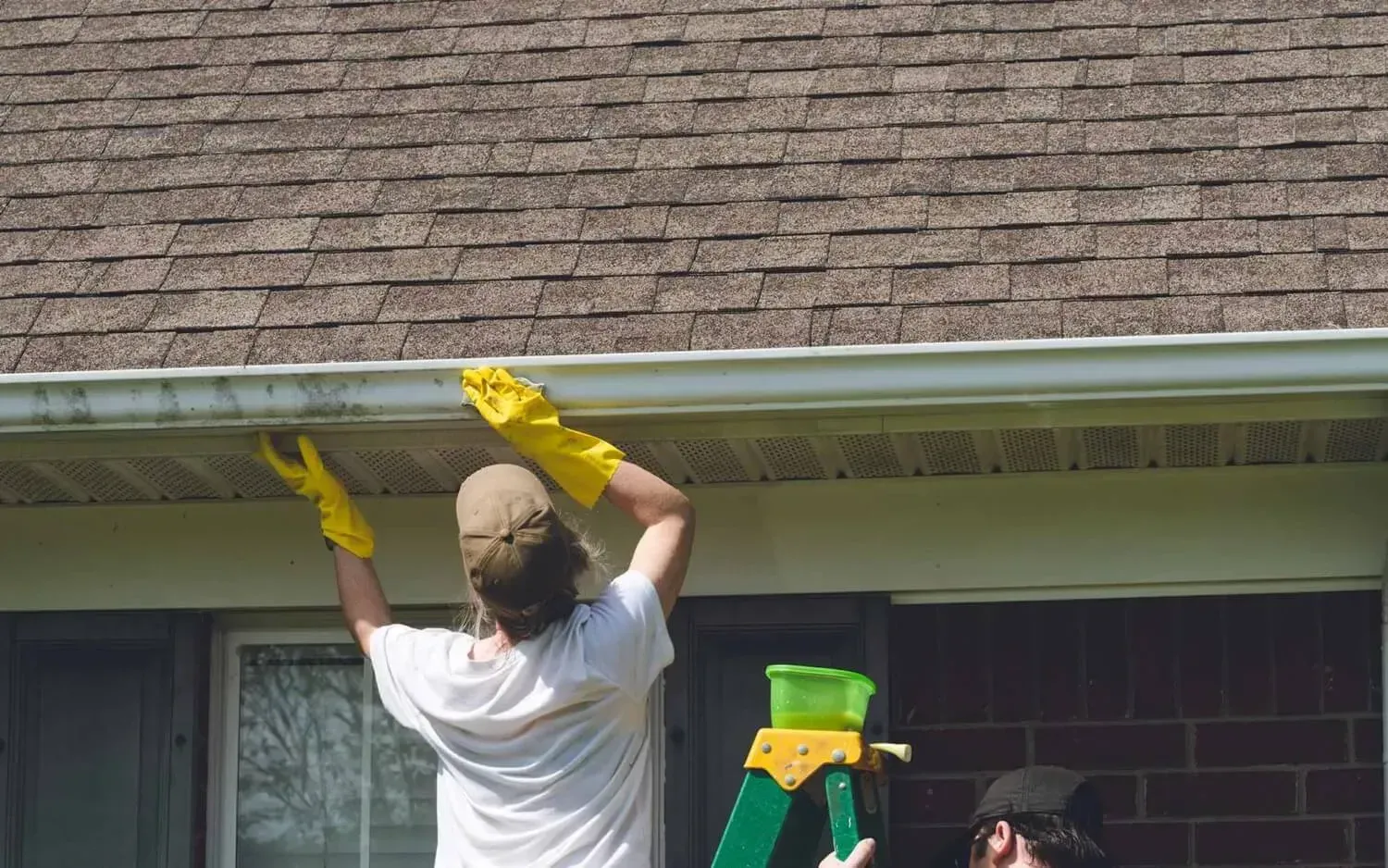 Residential gutters being cleaned on a house