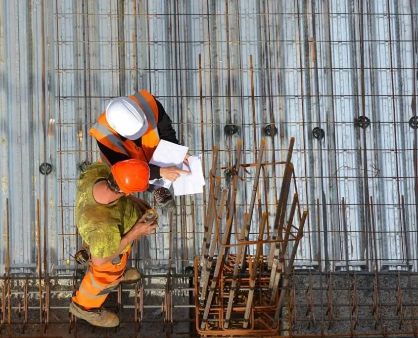 Two men overhead looking at checklist as they conduct a pre construction roof inspection