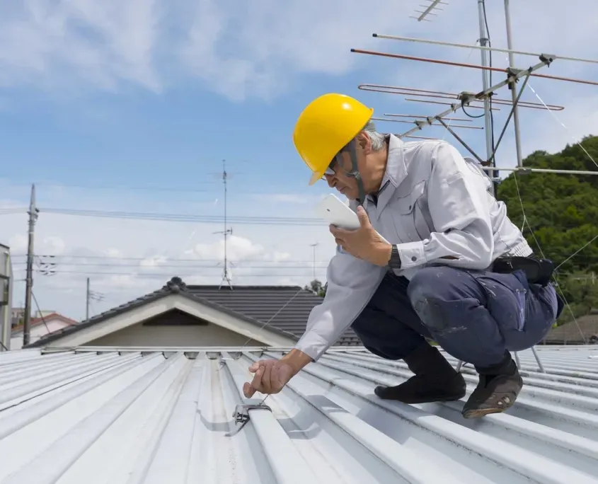 Worker on roof inspecting_October1